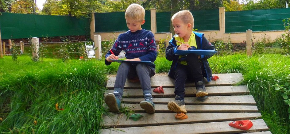 Dva chlapci na lezecé stěně v montessori zahradě školky Duhovka.